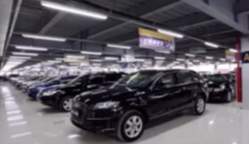 Image 68: A black car is being displayed in a car showroom